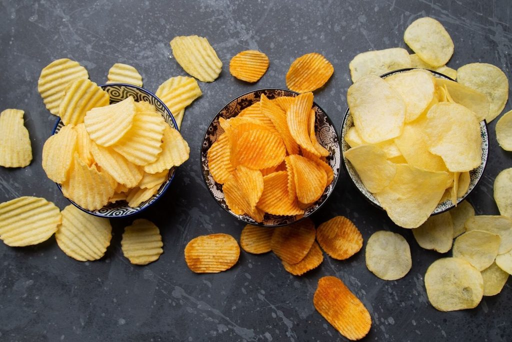 Potato chips or crisps, popular salty snack served in bowl